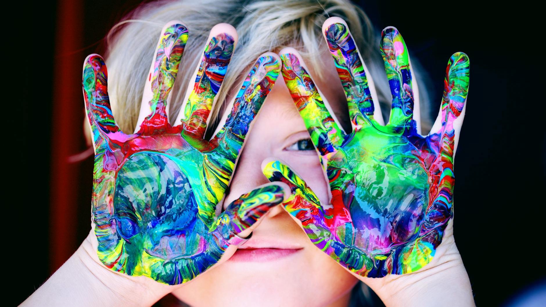 a kid with multicolored hand paint